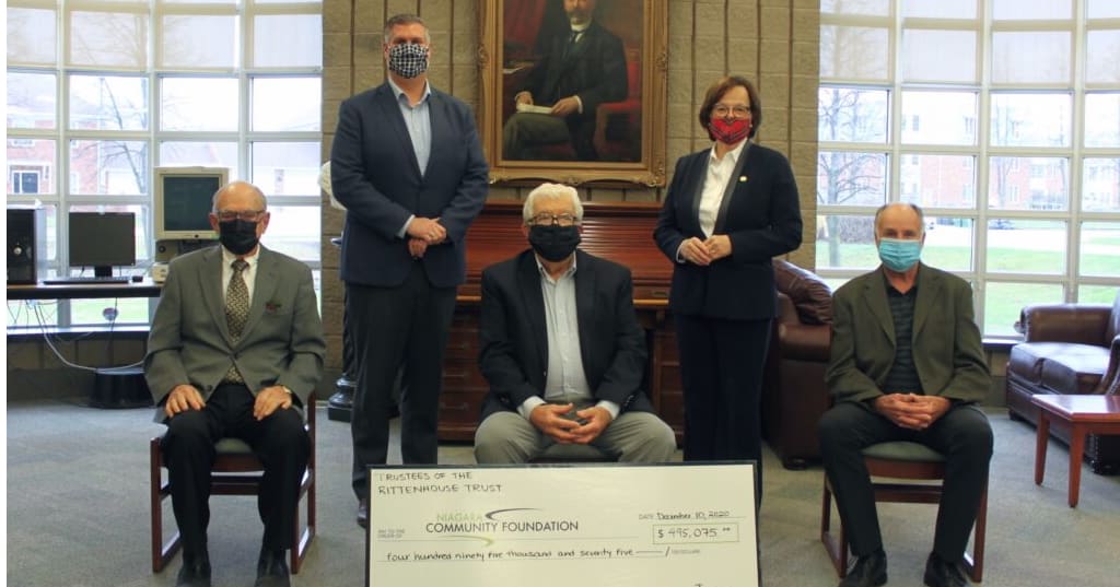 Group of people posing with oversized donation cheque.