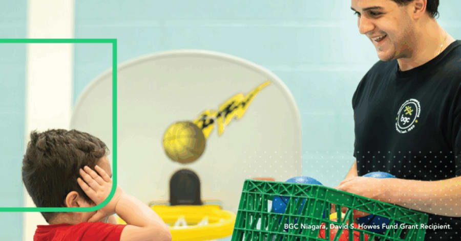 A member of the Boys and Girls Club is bringing a young boy a crate of toy balls in a gym.